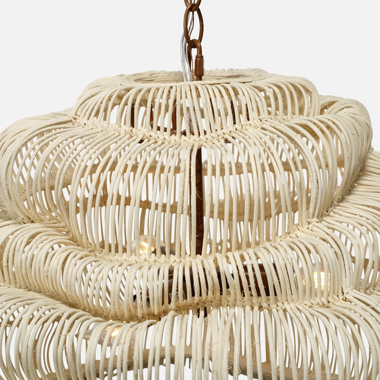 Close-up of a beige woven rattan pendant light against a white background