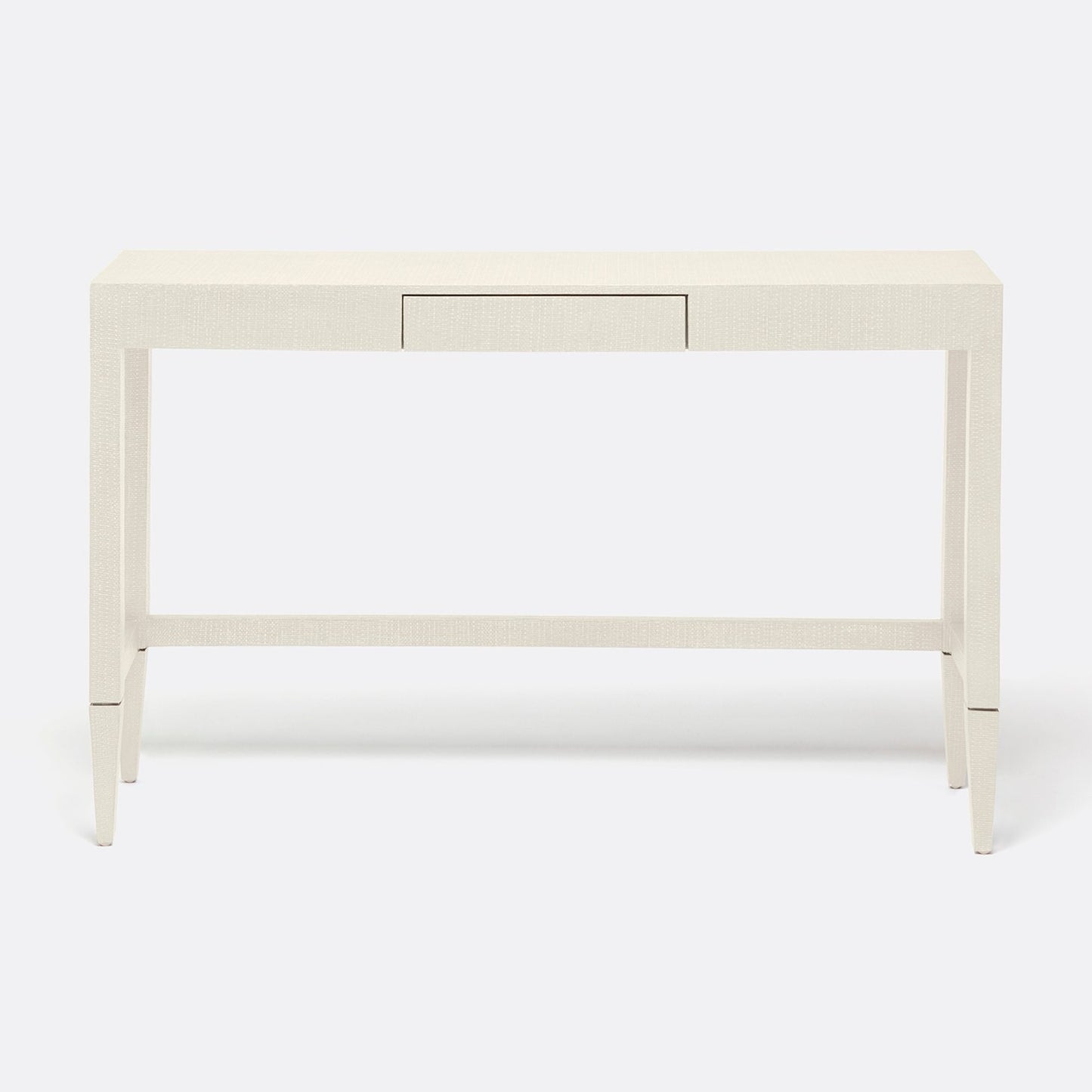 A modern console table with a light beige textured finish, featuring a single drawer, tapered legs, and a lower support rail, shown against a plain white background.