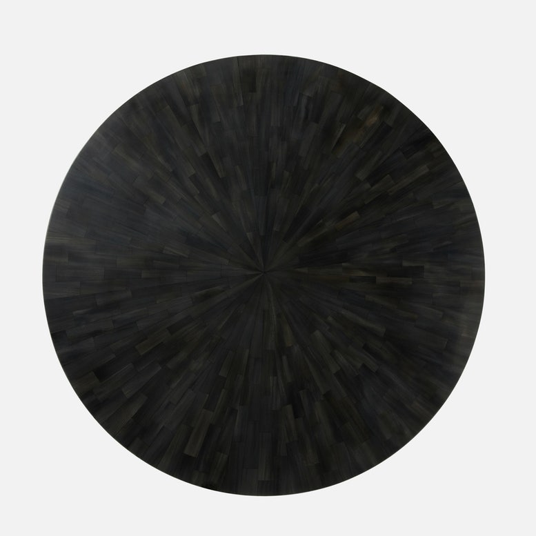 Black round table with a textured surface on a white background