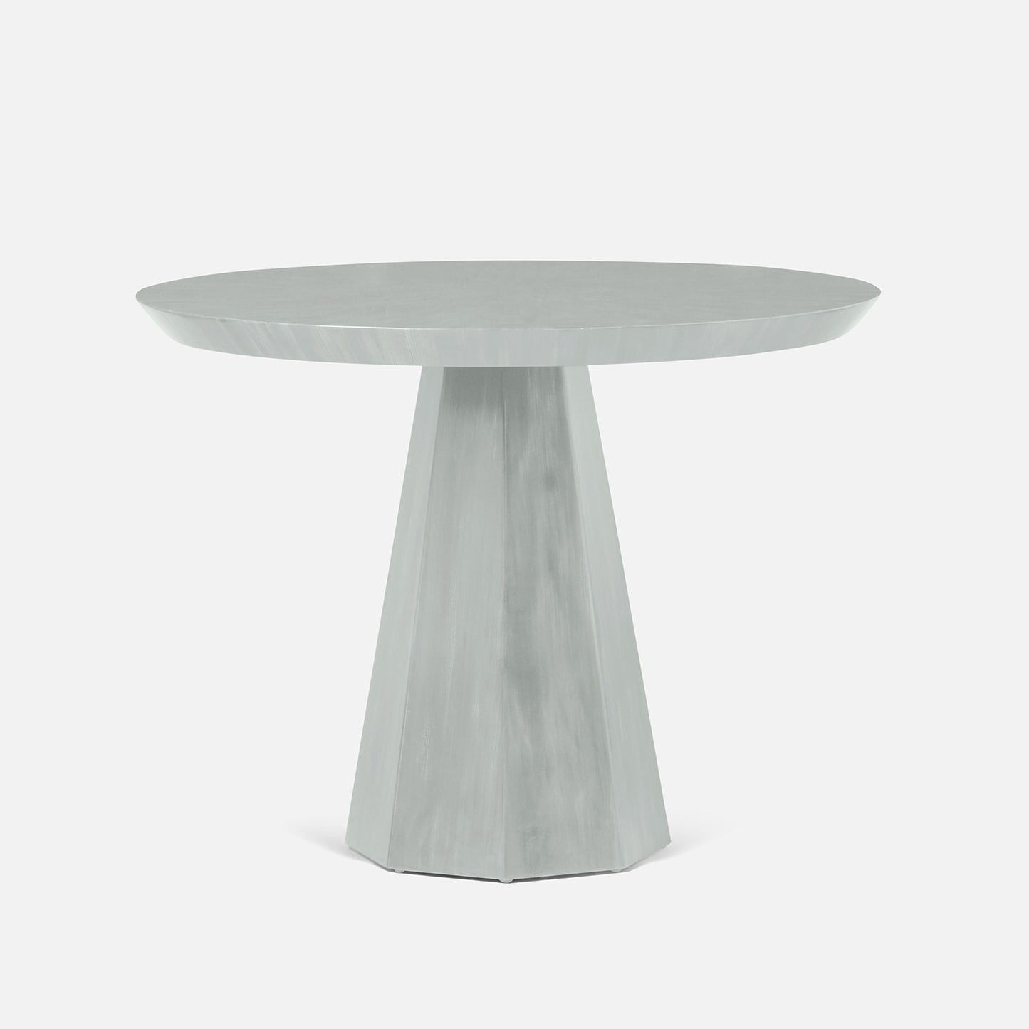 Round white table with a geometric base on a white background