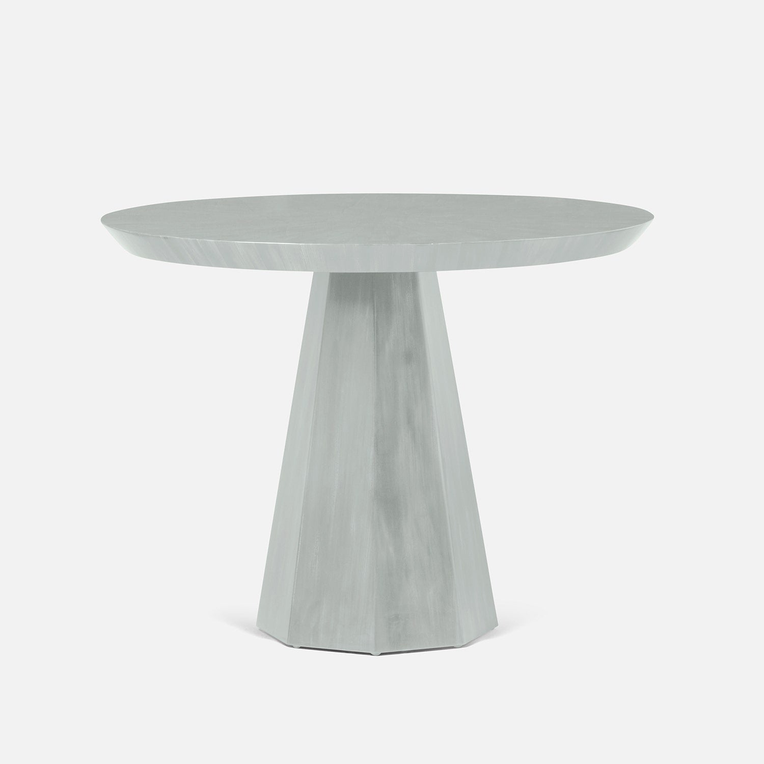 Round white table with a geometric base on a white background