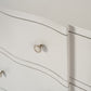 Close-up of a white dresser with a decorative silver handle.