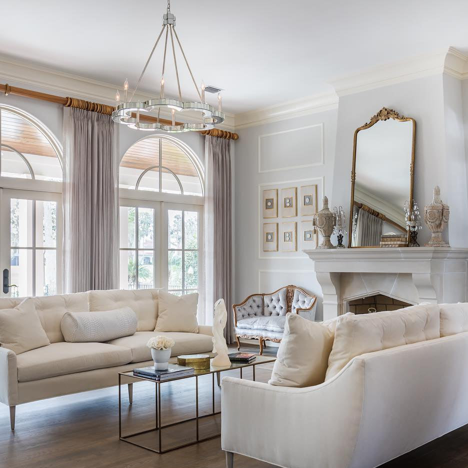 Living room with white sofas, a coffee table, and decorative elements.