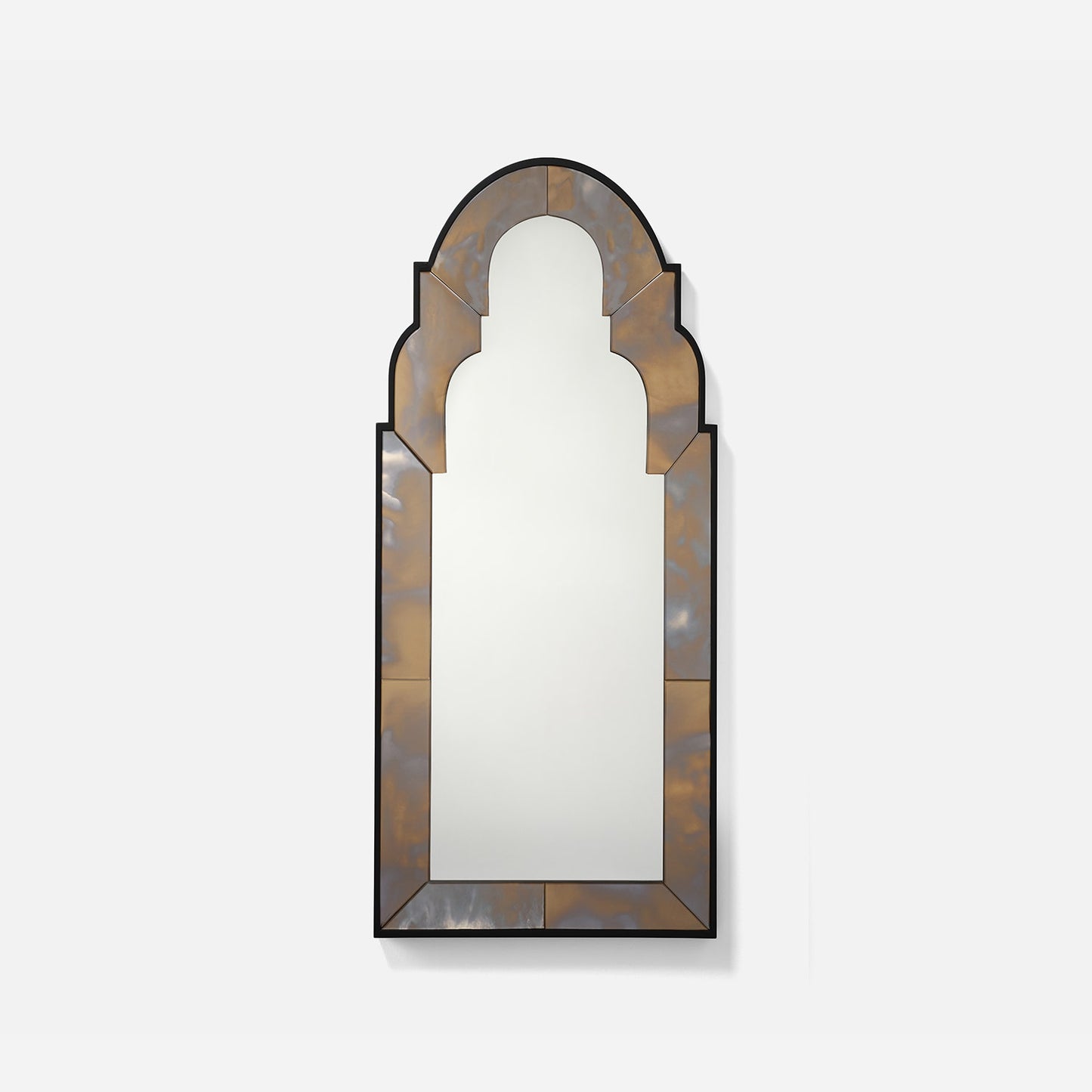 Decorative wall mirror with an arch-shaped frame on a white background