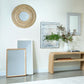 Living room with various mirrors and a vase on a table.