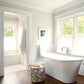 Bathroom with a freestanding bathtub, wooden floor, and large window.