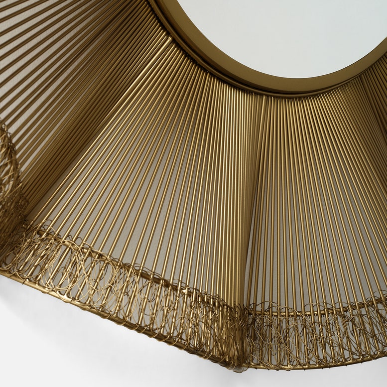 Close-up of a gold lampshade with pleated design on a white background