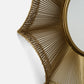 Gold decorative wall mirror with intricate design on a white background