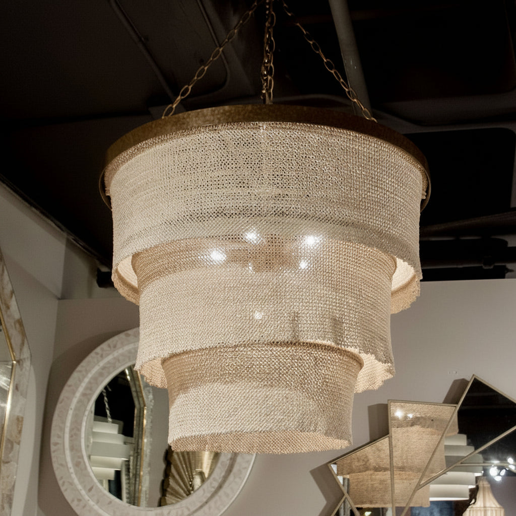 Chandelier hanging from the ceiling in a room with mirrors and decorative elements.