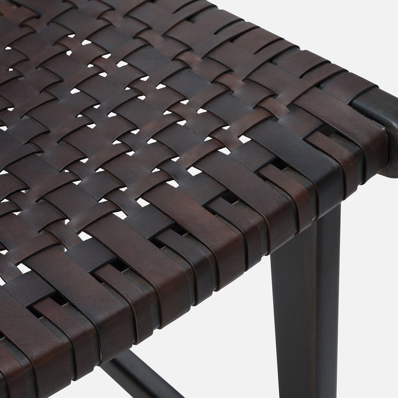 Close-up of a woven brown chair seat with a white background