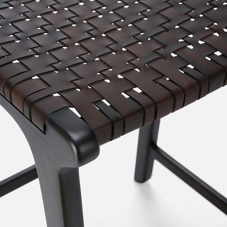 Close-up of a woven brown chair seat with metal legs on a white background