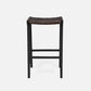 Black bar stool with woven seat on a light gray background