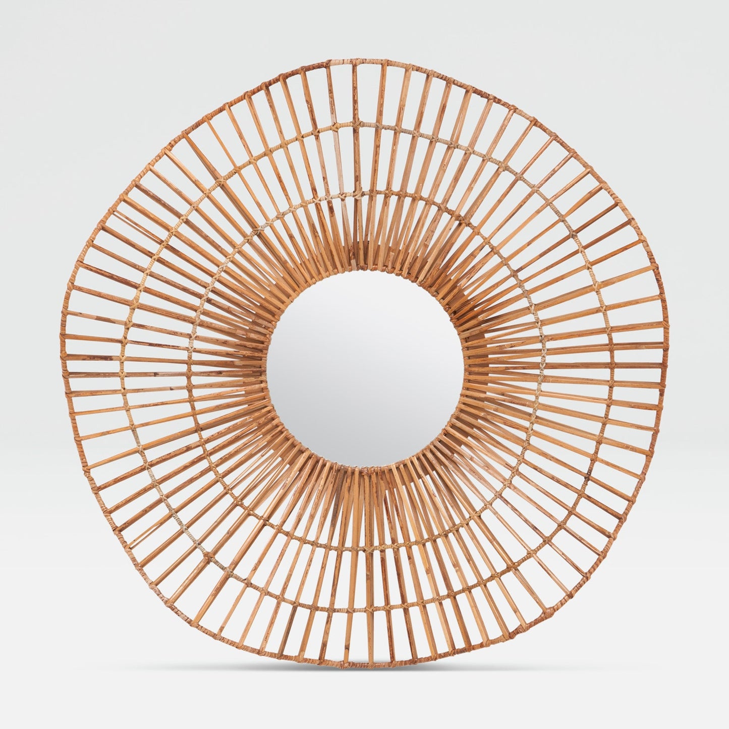 Round rattan mirror with a white center on a light gray background