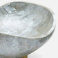 Close-up of a textured stone bowl on a white background