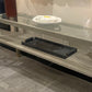 Glass shelf with a black tray on a tiled floor