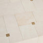 Beige tiles with gold accents arranged in a herringbone pattern on a light background