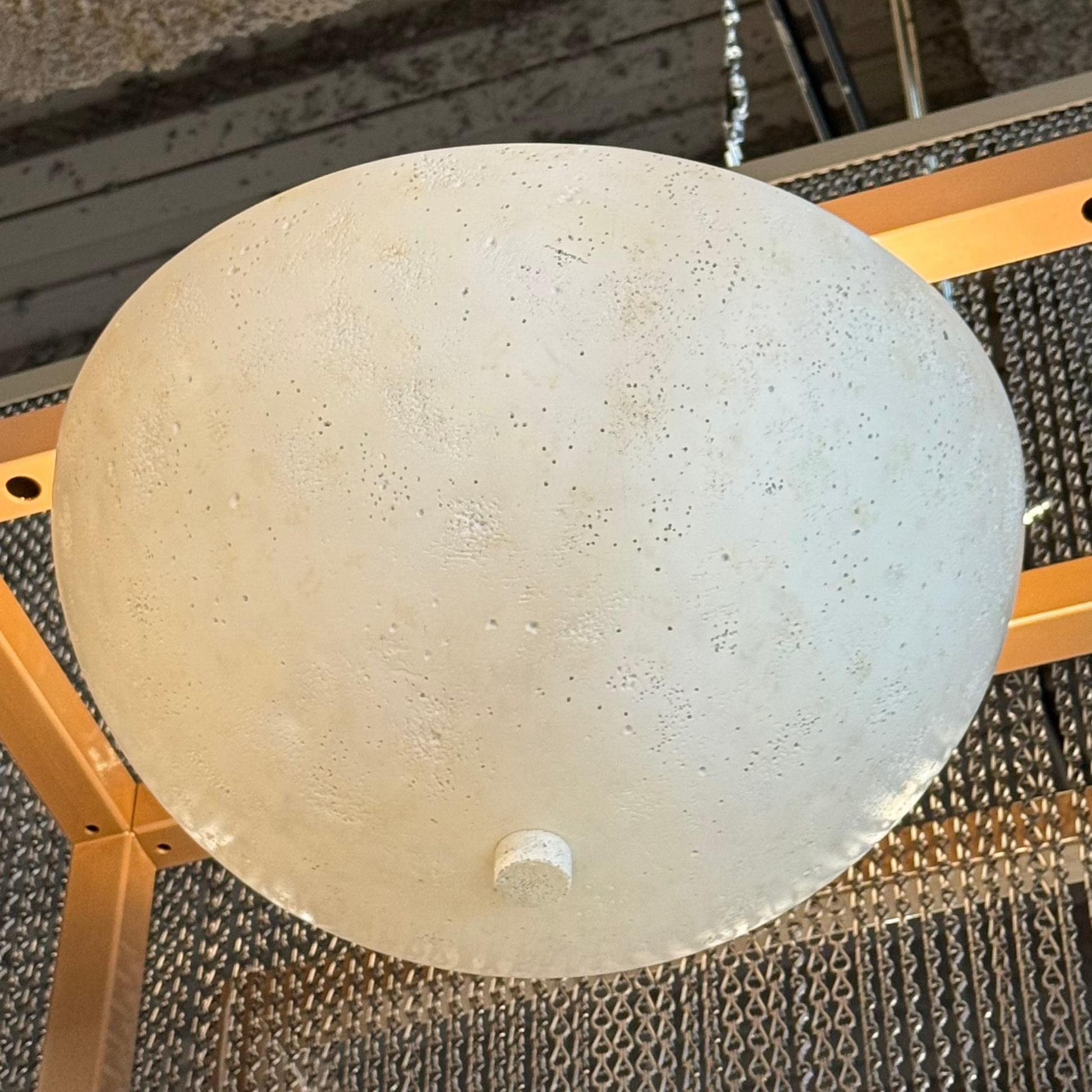 Round concrete-like object on a textured surface