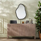Wooden vanity with decorative mirror and plants in a room setting