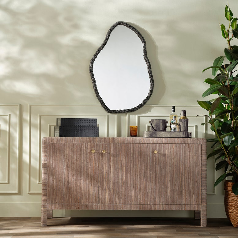 Wooden vanity with decorative mirror and plants in a room setting