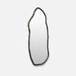 Decorative mirror with a textured frame on a light gray background