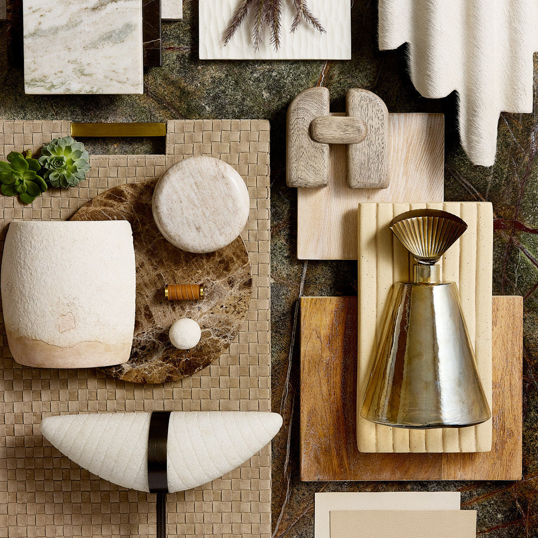 Collection of decorative items including vases, bowls, and a candle on a textured surface.