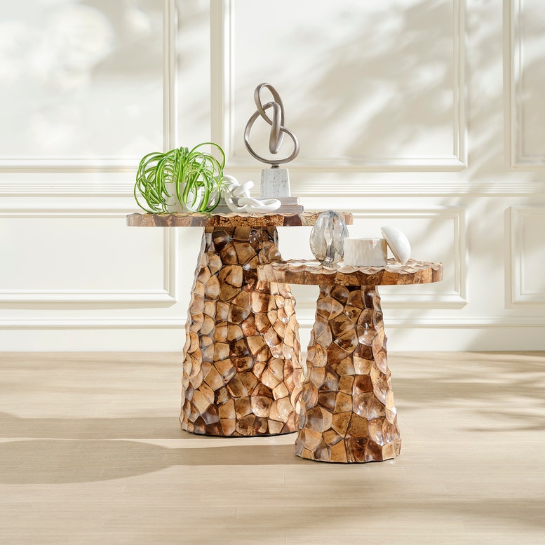 Two wooden side tables with decorative items against a white wall.