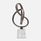Abstract metal sculpture with intertwined rings on a white background