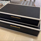 Black jewelry box with gold accents on a table