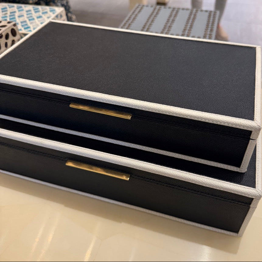 Black jewelry box with gold accents on a table