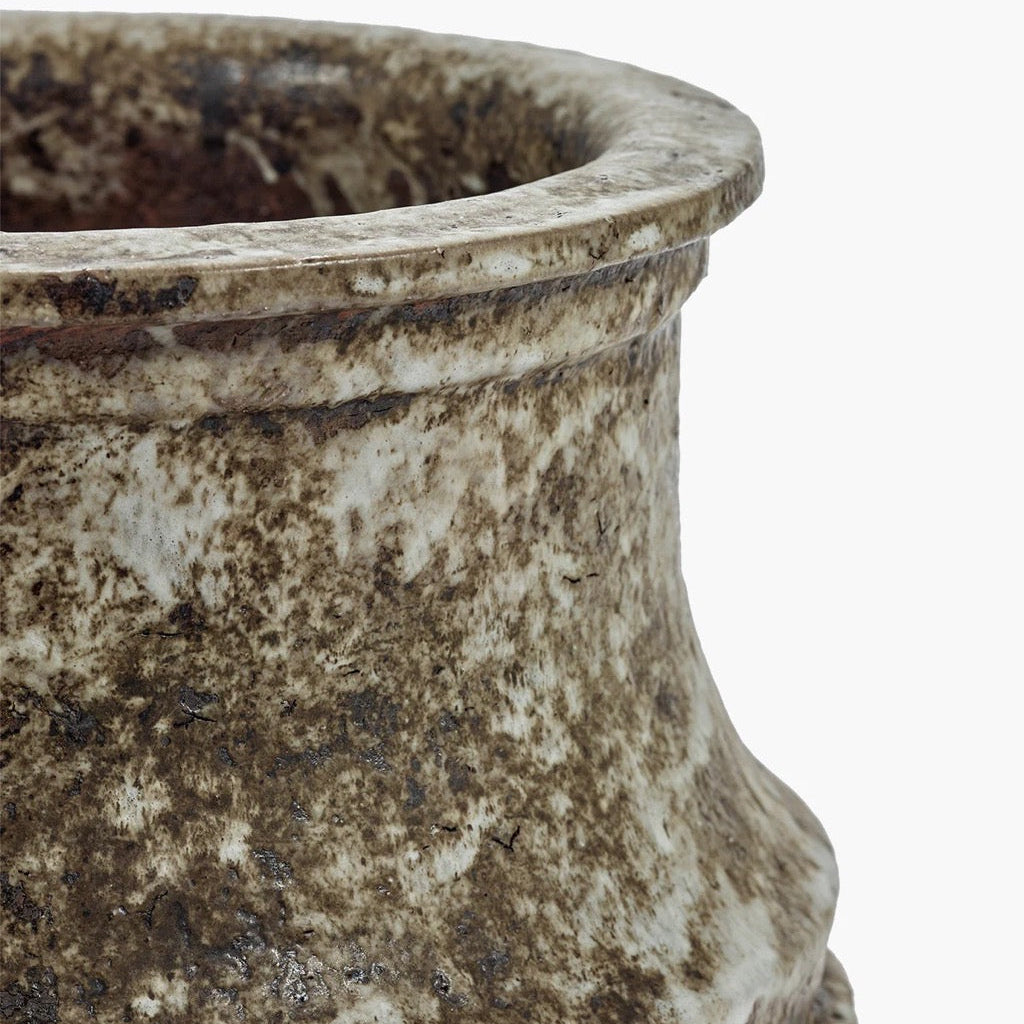 Close-up of a textured stone vase on a white background