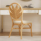 Rattan chair with leaf-patterned backrest in front of a desk.