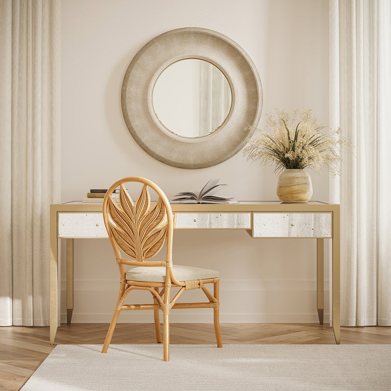 Wooden desk with a chair and decorative items in a room with curtains.