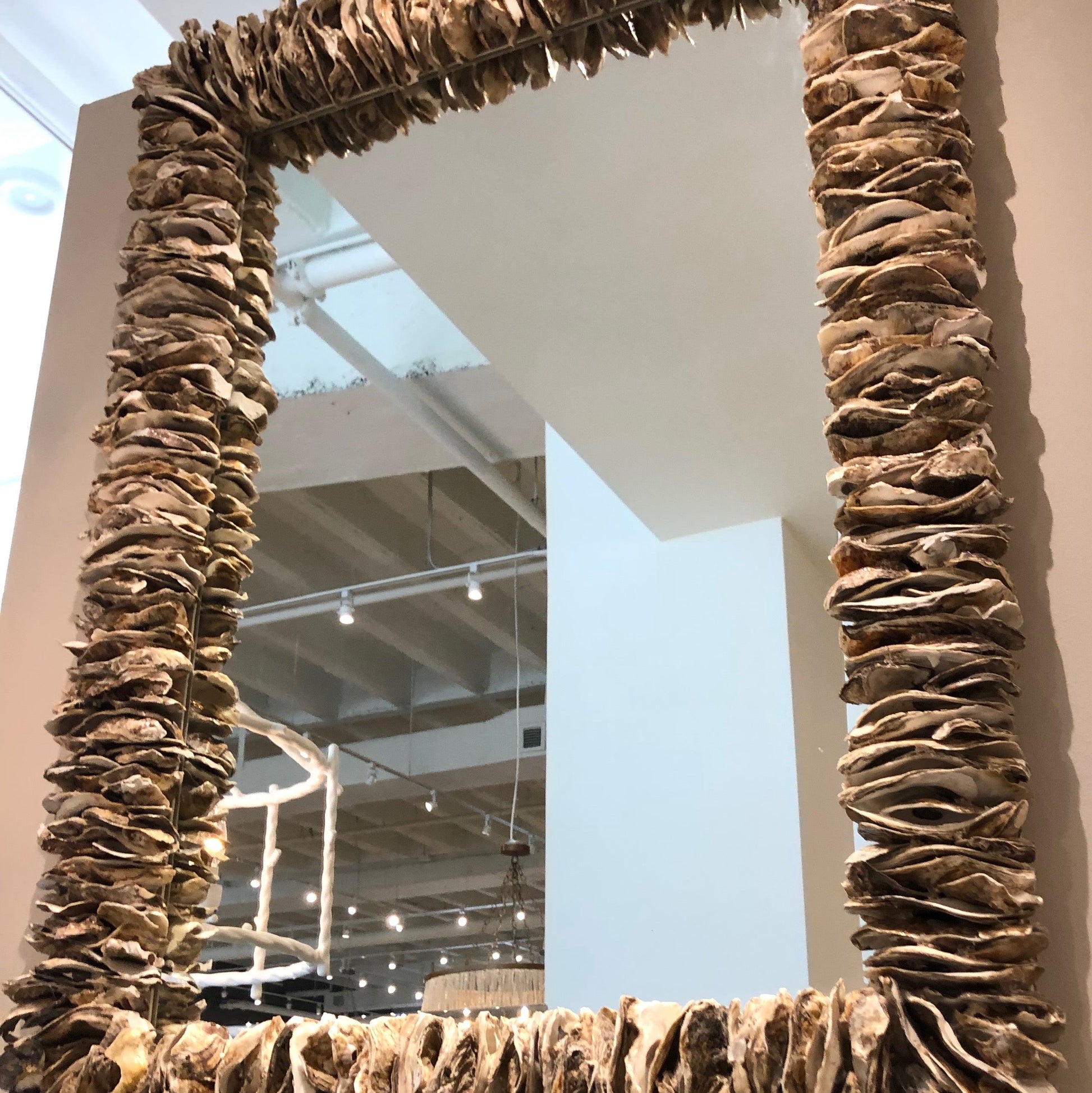 Decorative mirror with a textured brown frame on a wall.