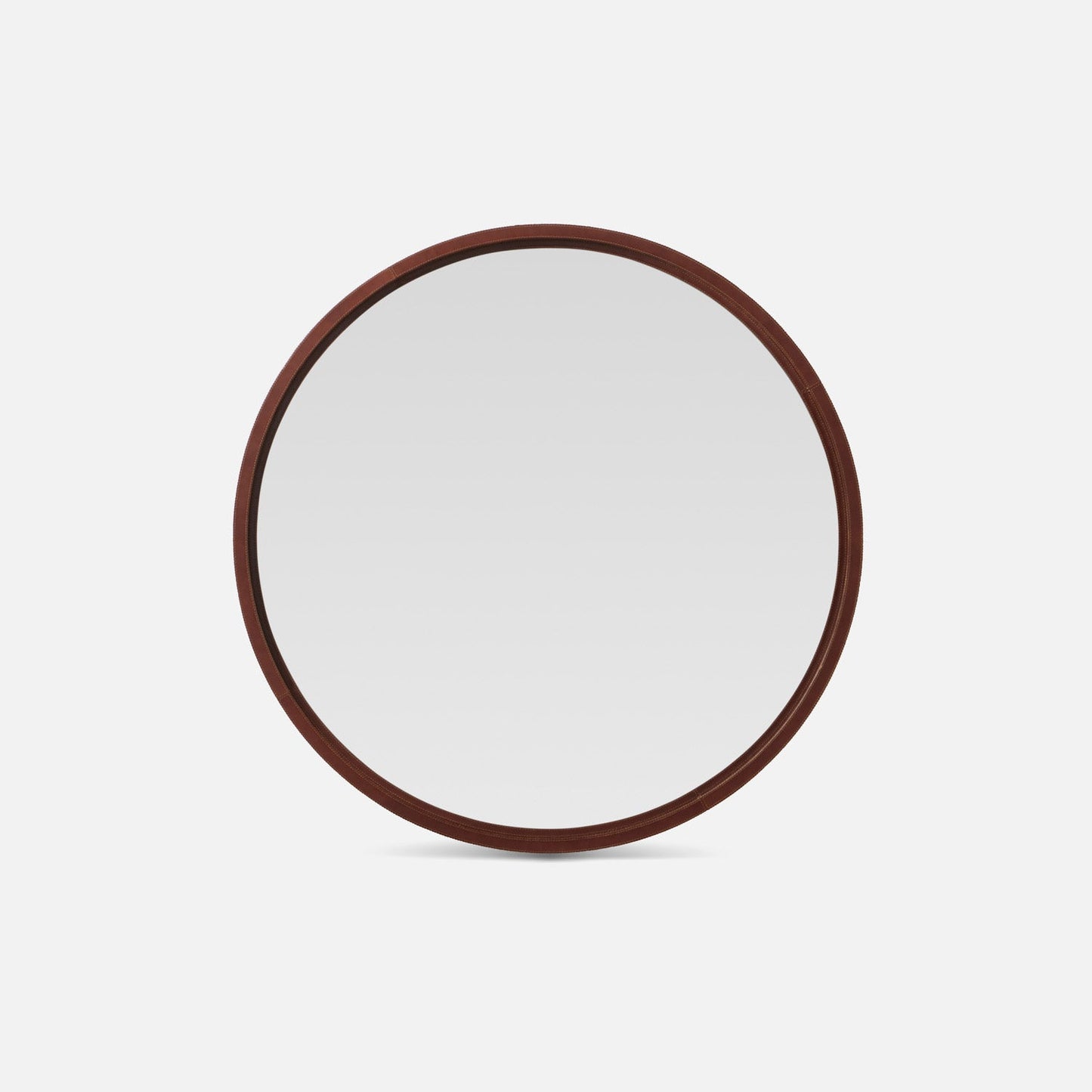 Round mirror with a leather frame on a white background