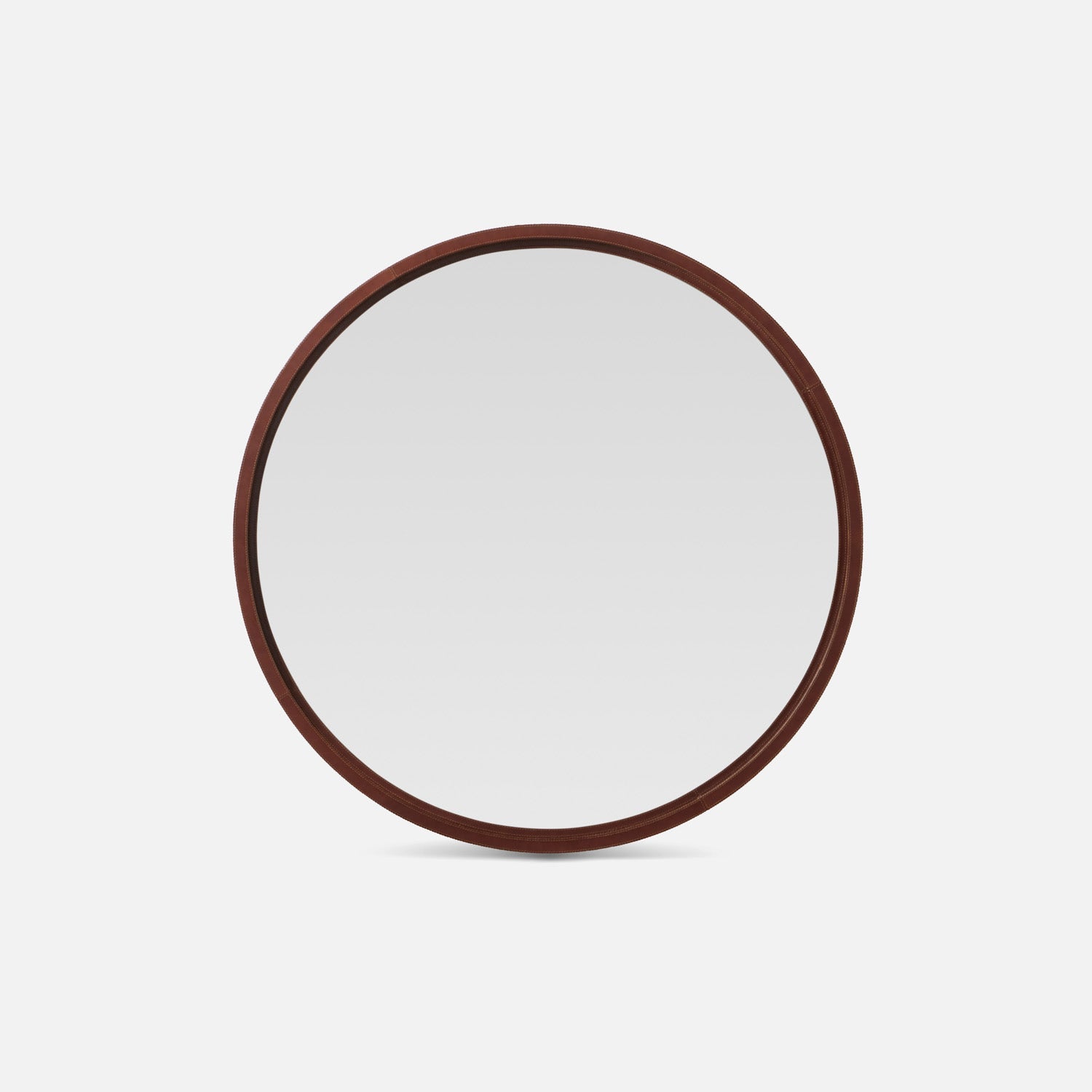 Round mirror with a leather frame on a white background