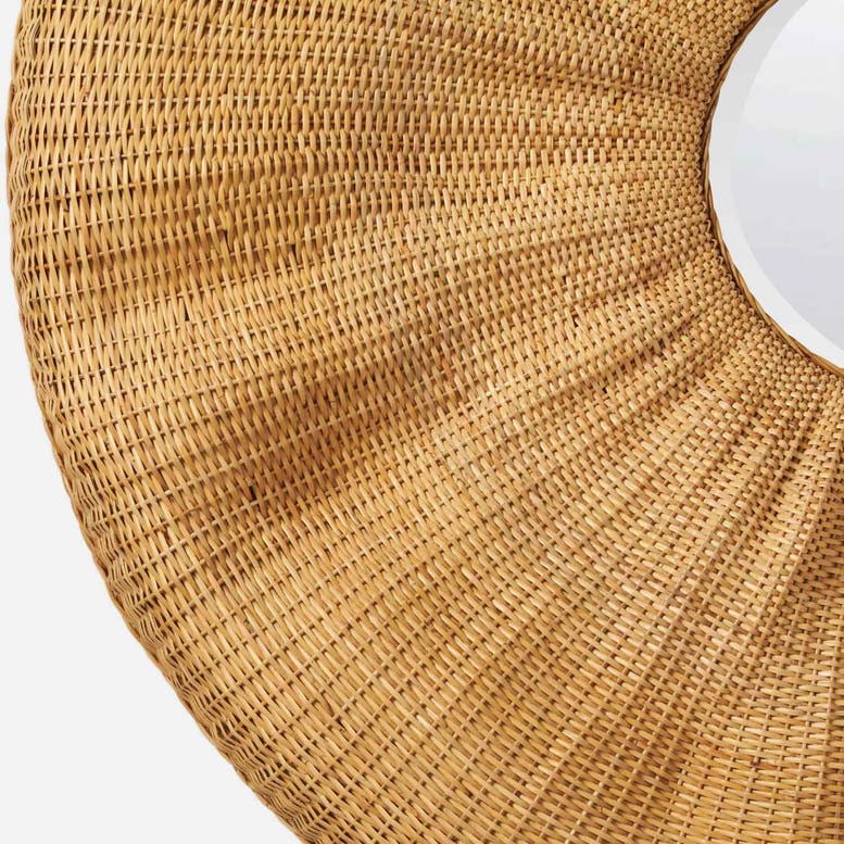 Close-up of a round woven natural straw or rattan rug with a circular cutout in the center, shown on a light neutral background.