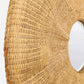 Close-up of a woven natural rattan or wicker circular wall mirror with a light wood frame, showing the detailed texture and weave pattern against a white background.