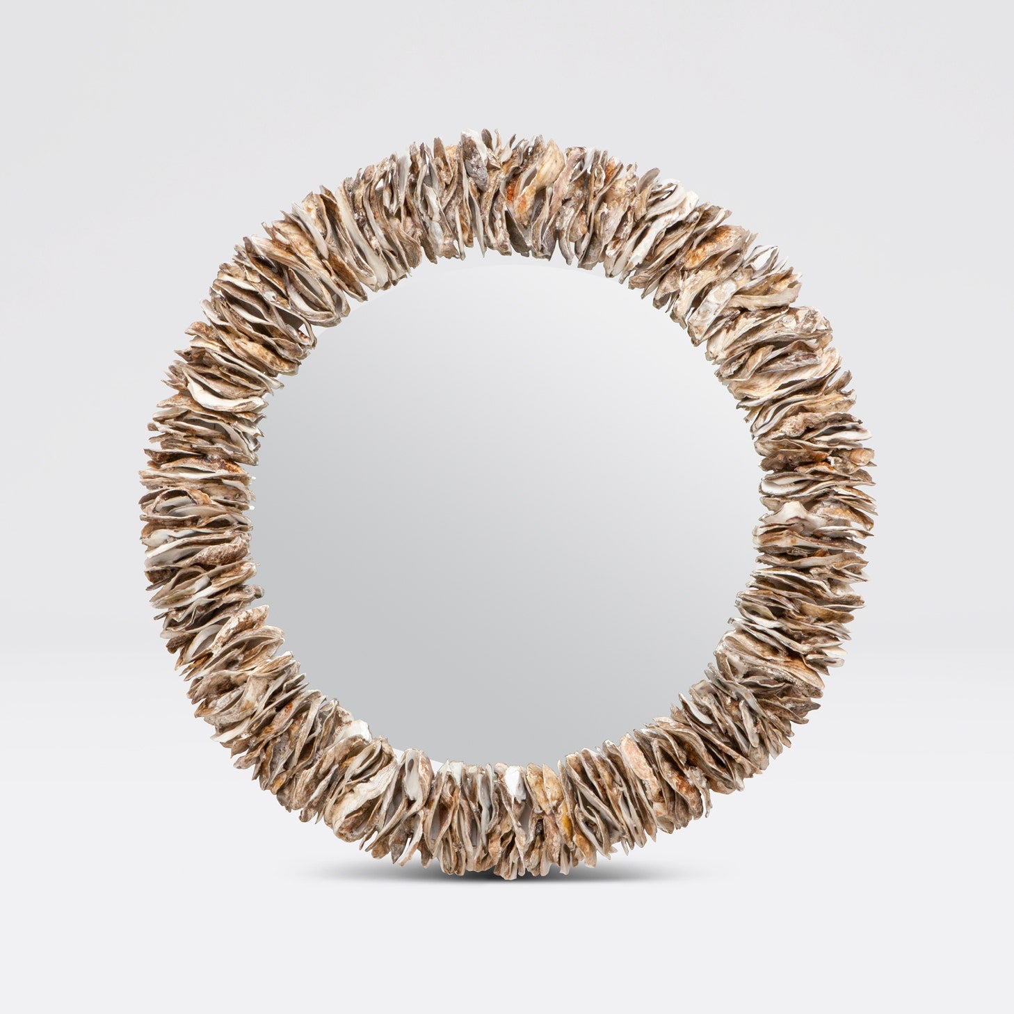 Round mirror with a natural, organic frame on a light gray background