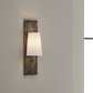 Wall-mounted light fixture on a plain wall with a large window in the background