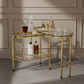 Gold bar cart with drinks and glasses against a neutral wall.
