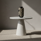 Ceramic vase on a white pedestal table with soft shadows in a minimalistic room.