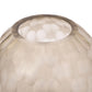 Close-up of a textured glass lampshade with a soft glow on a white background
