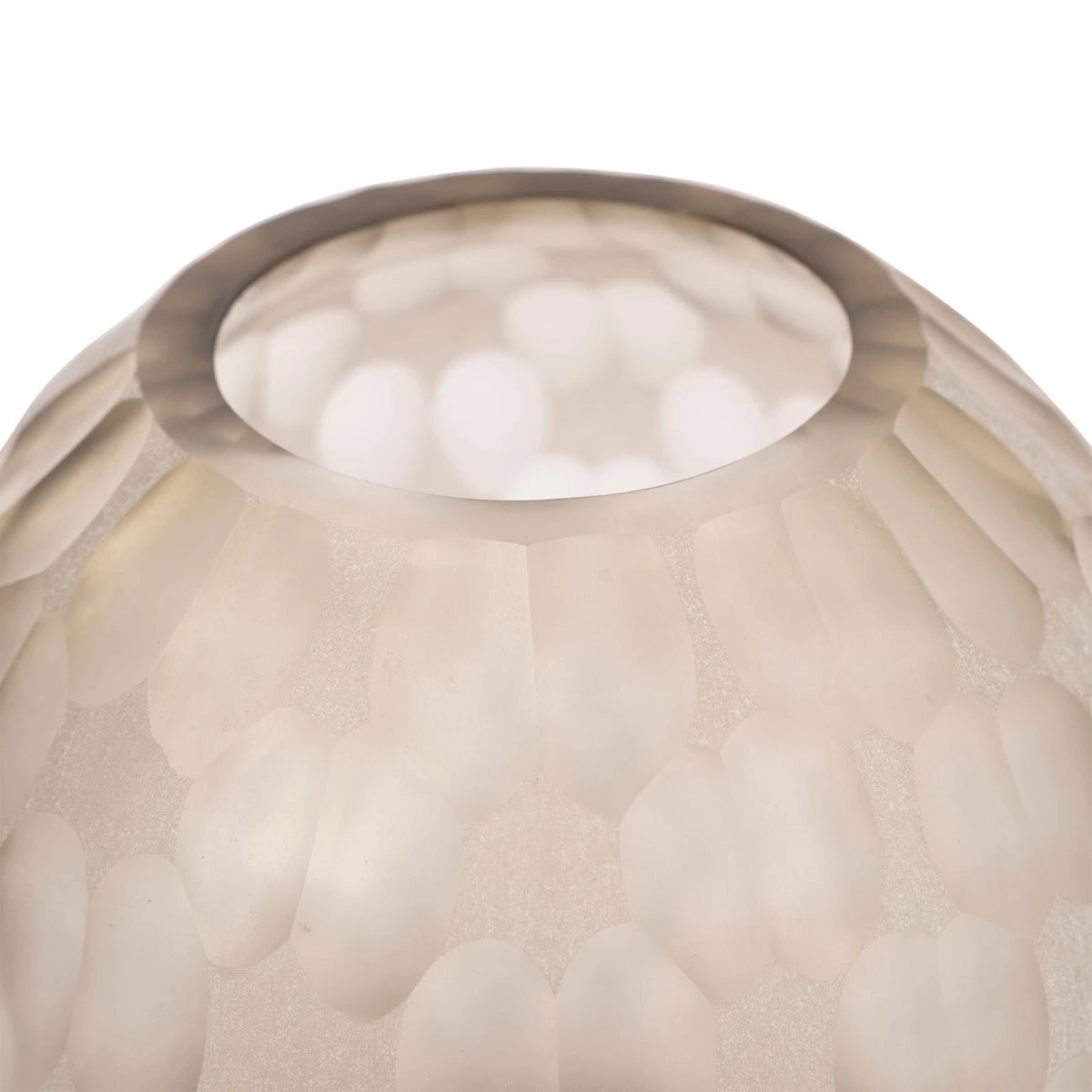 Close-up of a textured glass lampshade with a soft glow on a white background