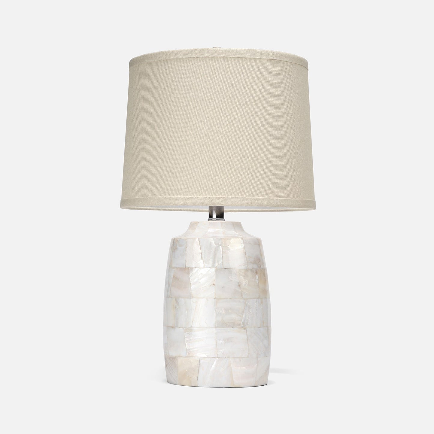Table lamp with a decorative base and beige shade on a white background