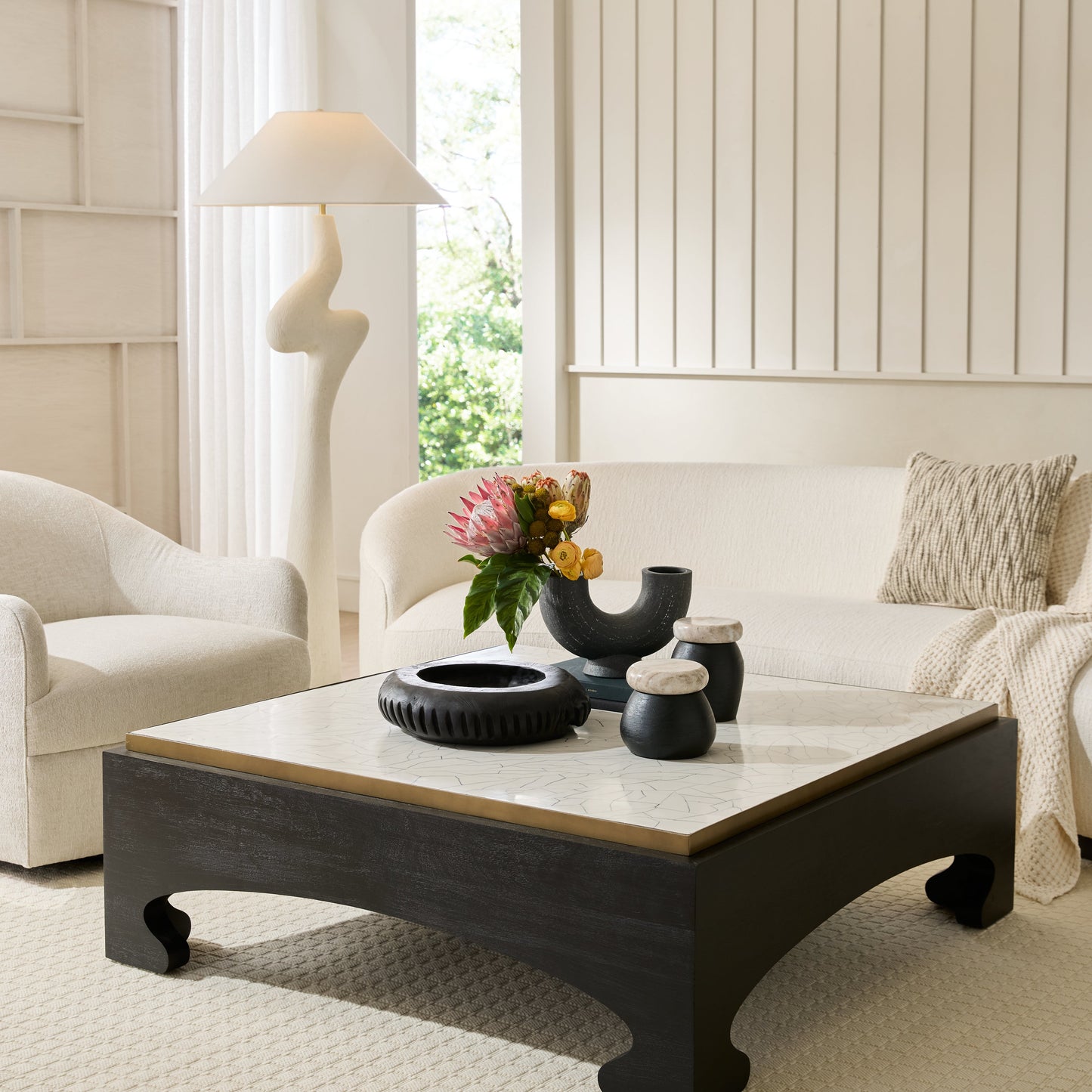 Modern living room with a white sofa, coffee table, and decorative items.
