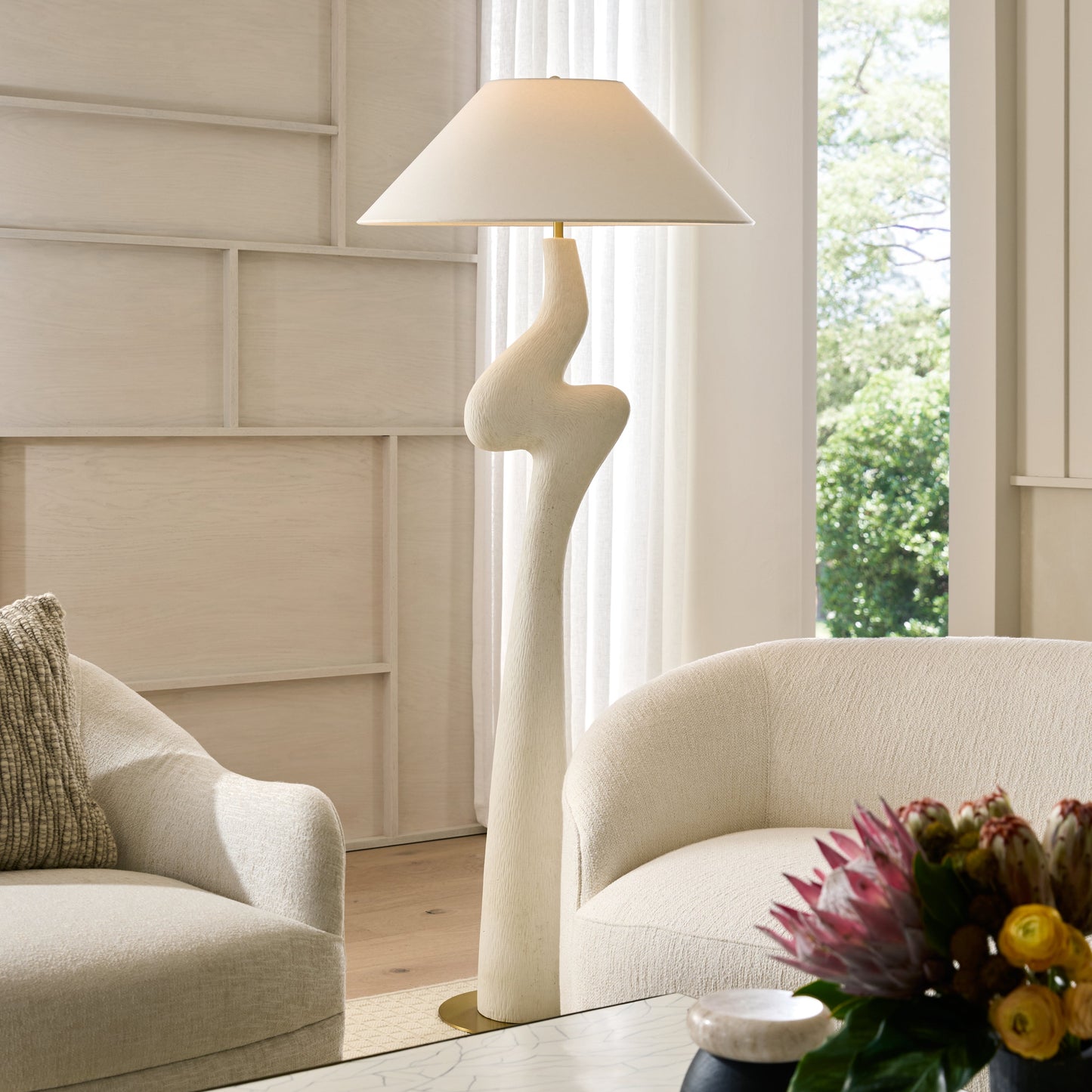 Modern living room with a unique floor lamp and decorative elements.