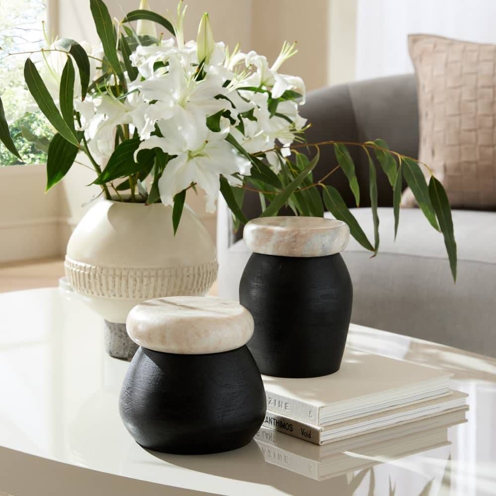 Decorative vases with white flowers on a coffee table in a living room.