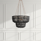 Black chandelier hanging against a white paneled wall