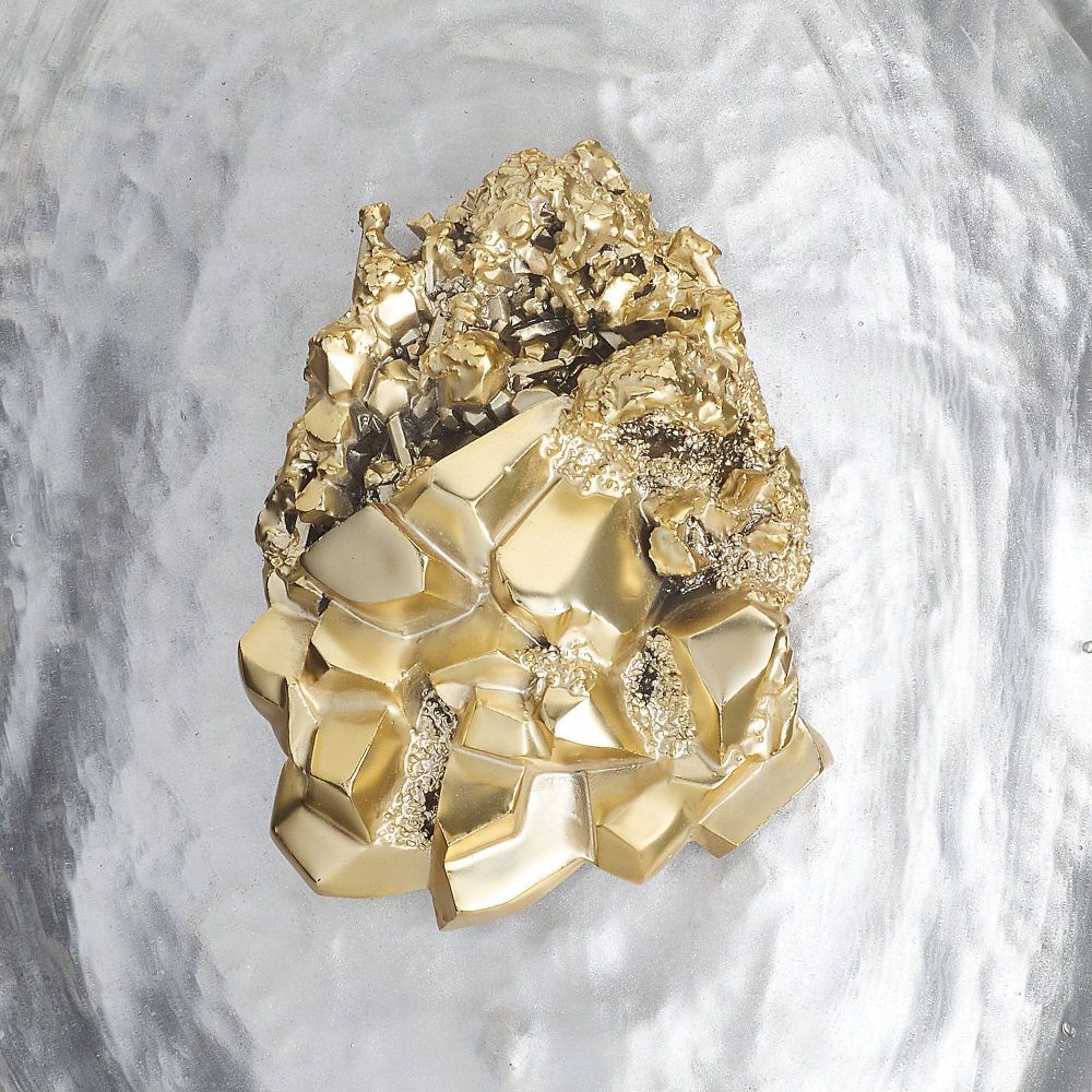 Gold mineral crystal on a marble background