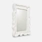 Decorative mirror with a textured white frame on a light gray background